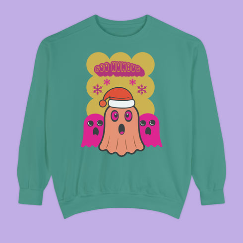 A holiday sweatshirt featuring a cute ghost character wearing a Santa hat, with two smaller ghosts on either side. Above them is the playful text "Boo Humbug," surrounded by snowflakes and festive elements. The design humorously combines spooky and festive themes for a unique holiday look.